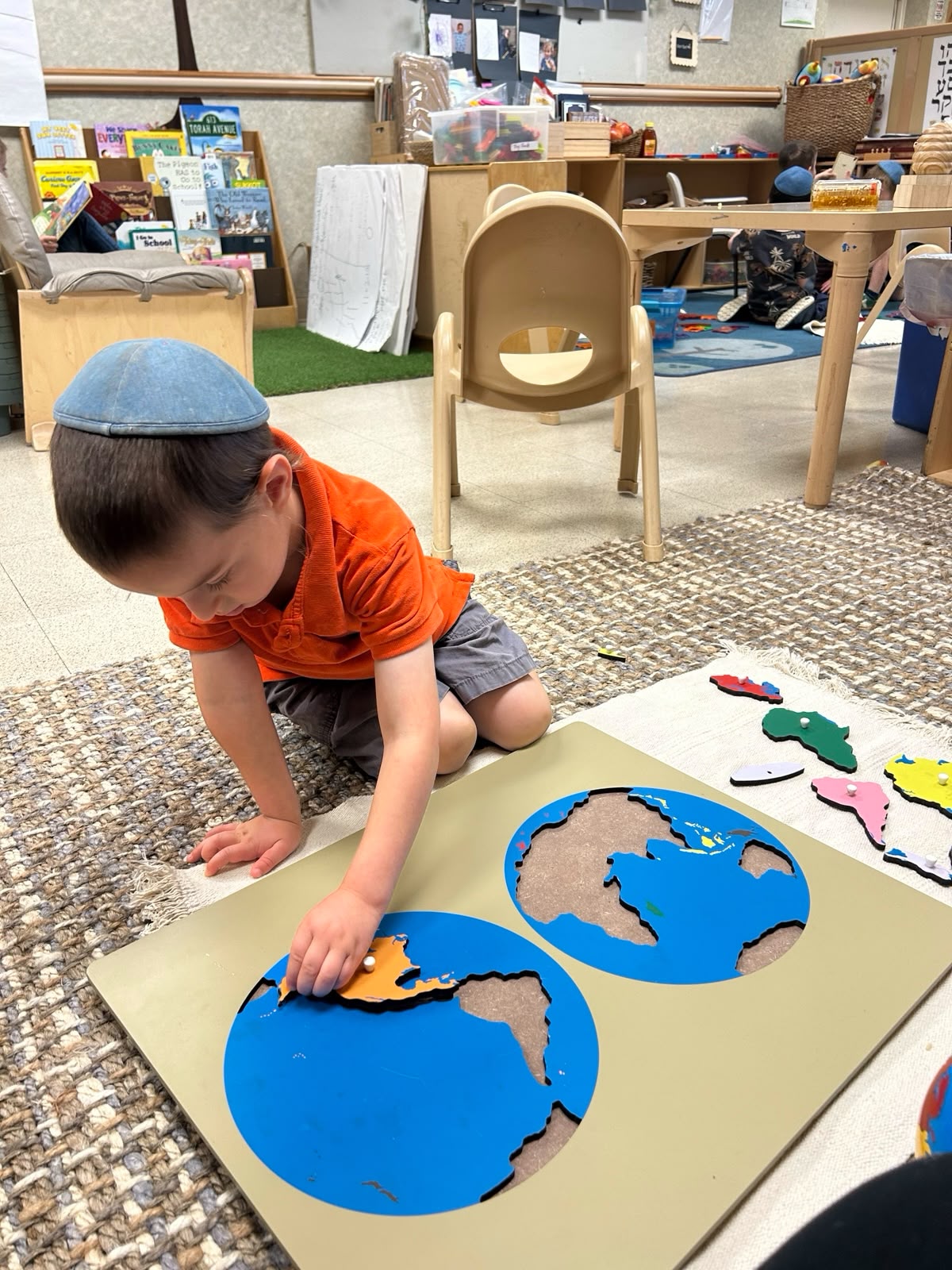 A child working on a world puzzle in the classroom