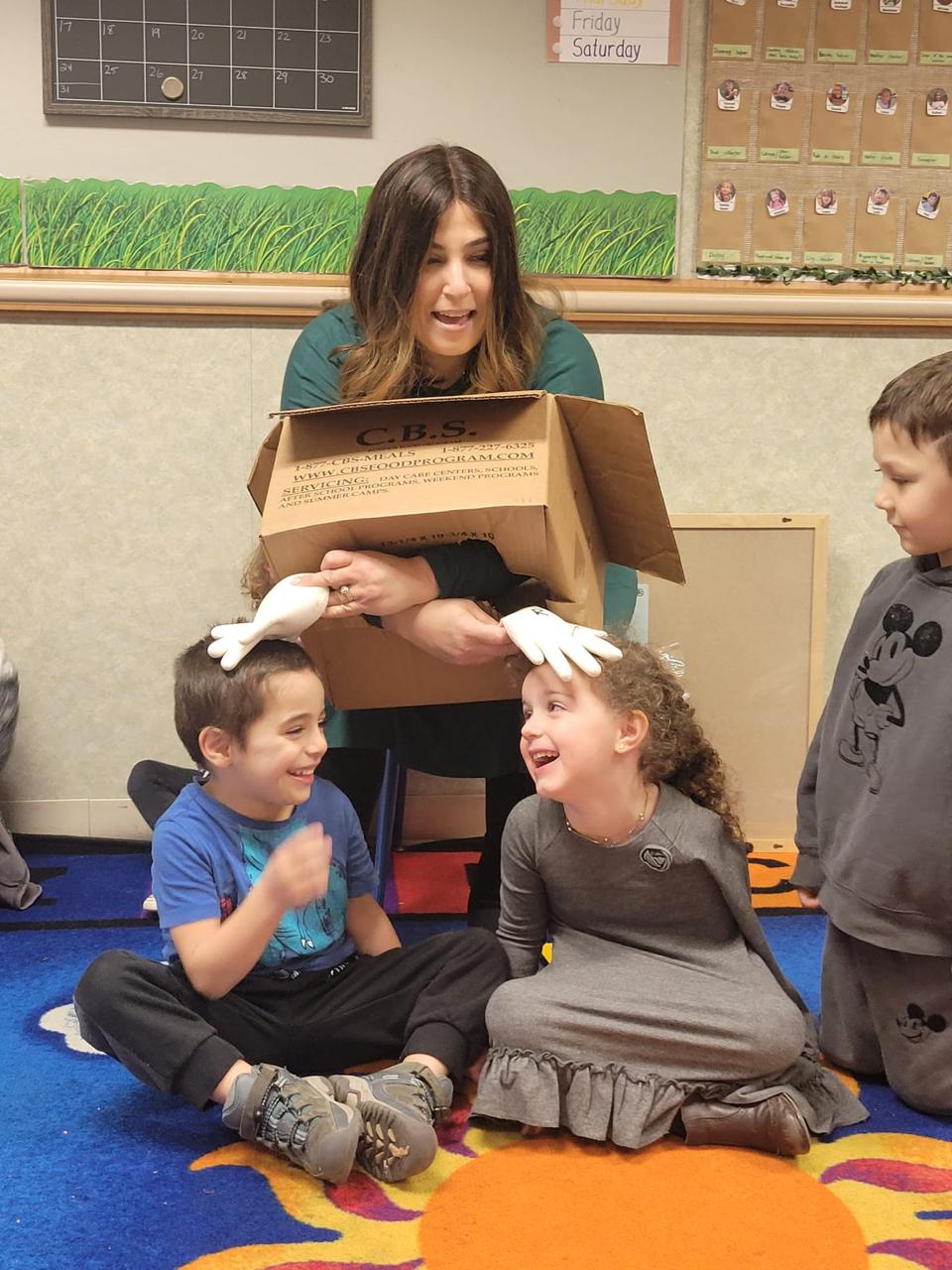 Two of Doba's preschool students with challah, dressed up for Shabbos